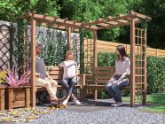 Gerlinde corner garden arbour with seat and trellis by Dunster house with people