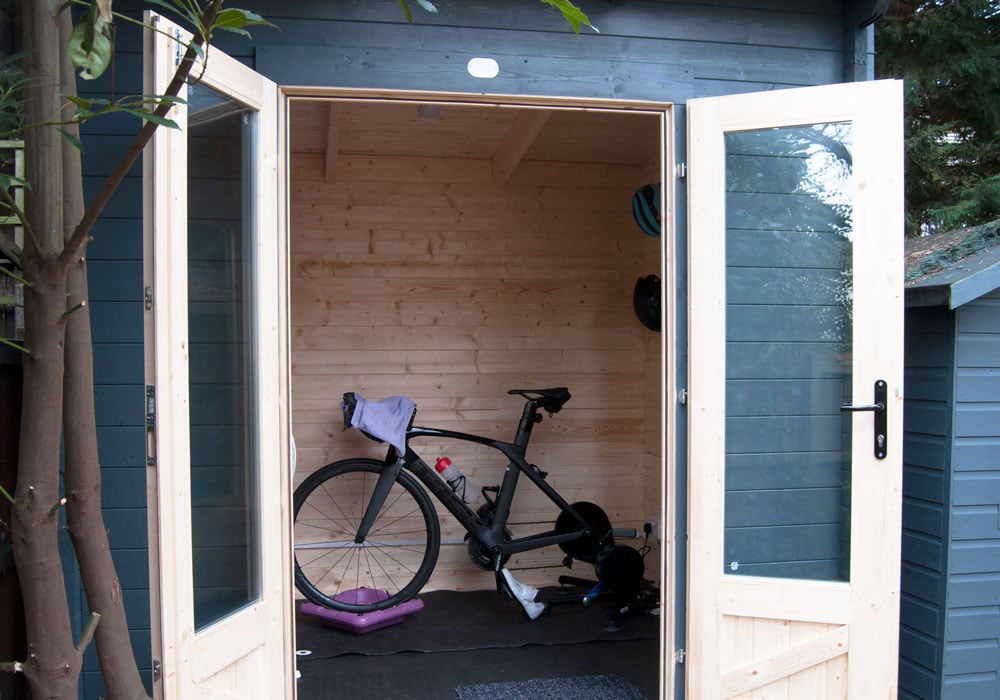 The "Pain Cave," a , wooden log cabin used as a training space by a Paralympic athlete (Lauren Steadman MBE), featuring a road bike and exercise equipment.